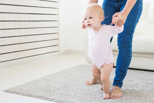 아기 유아의 첫 번째 단계는 흰색 햇볕이 잘 드는 거실에서 걷는 법을 배워야합니다. 아동용 신발. — 스톡 사진