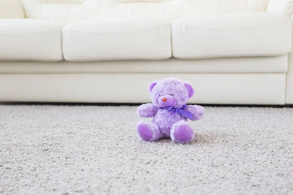 Concepto de infancia y niñez: oso de peluche sentado en una alfombra beige en el dormitorio — Foto de Stock