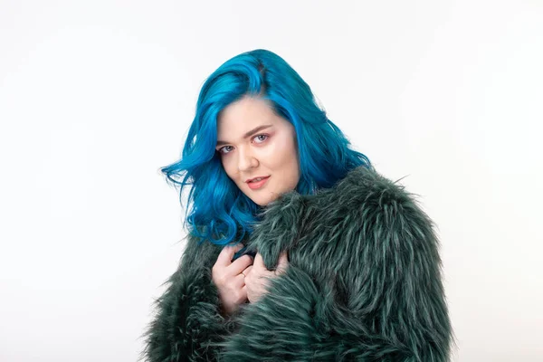 Proteção animal, moda e conceito de cabelo - menina bonita com cabelo azul vestido com casaco de pele artificial em pé sobre fundo branco — Fotografia de Stock