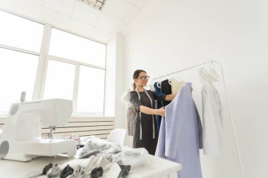 Terzi, moda tasarımcısı, terzi ve insanlar kavramı - genç kadın moda tasarımcısı onu showroom