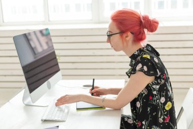 Grafik tasarımcı, animatör ve illüstratör kavramı - kırmızı saçlı genç kadın dizüstü bilgisayarda çalışıyor