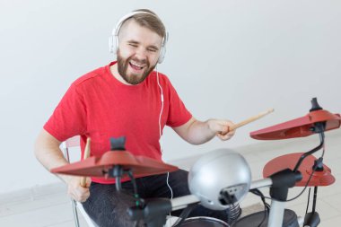 Davulcu, hobiler ve müzik konsepti - elektronik davul çalan kırmızı gömlekli genç adam davulcusu