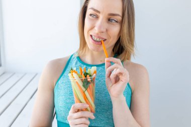 Sağlıklı yaşam tarzı kadın sebze yeme mutlu kapalı gülümseyerek. Sağlıklı yemek yiyen genç kadın yakın çekim.