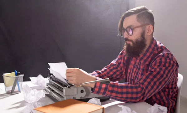 Koncepcja ludzi i technologii - Światowy dzień pisarza, przystojny mężczyzna w okularach, ubrany w koszulę w kratę, praca na maszynie do pisania — Zdjęcie stockowe