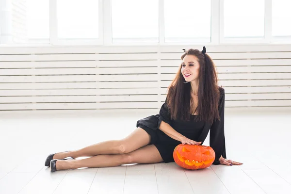 Halloween und Maskerade Konzept - schöne junge Frau posiert mit Kürbis Jack-o-Laterne — Stockfoto