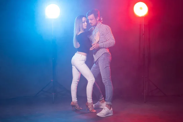 Baile social, bachata, salsa, kizomba, zouk y tango - Hombre abraza a mujer mientras baila sobre luces — Foto de Stock