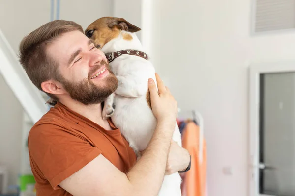 Animal, mascota y gente concepto Atractivo hombre alegre en camiseta sostiene mascota favorita — Foto de Stock