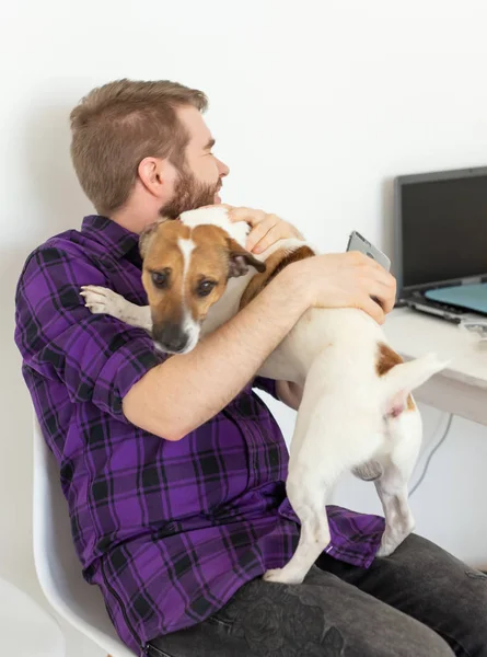 애완 동물 소유자 개념 - 잭 러셀 테리어 강아지 실내, 클로즈업과 놀고있는 젊은 남자 — 스톡 사진