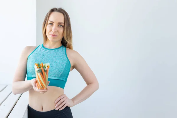 Concepto de dieta - Mujer estilo de vida saludable sosteniendo verduras en el interior. Mujer joven comiendo alimentos saludables, copyspace . —  Fotos de Stock
