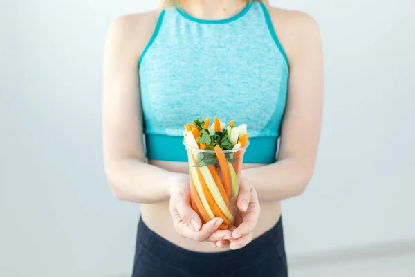 Conceito de dieta - close-up de mulher de estilo de vida saudável que mantém verduras em casa. Jovem do sexo feminino comer alimentos saudáveis . — Fotografia de Stock