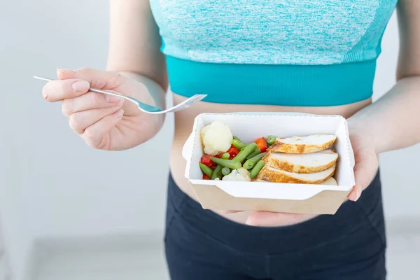 Υγιεινή διατροφή, δίαιτα και γυμναστική ιδέα-κοντά στη νεαρή γυναίκα που τρώει λαχανικά και κρέας μετά την προπόνηση — Φωτογραφία Αρχείου