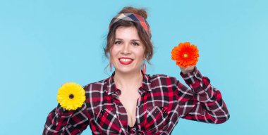 Yaz, pin-up ve eğlenceli kavram - mavi arka plan üzerinde gerberas ile güzel kadın