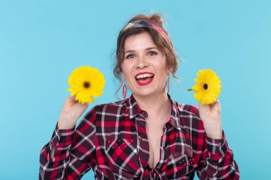 mavi arka plan üzerinde iki gerberas ile pin-up kadın