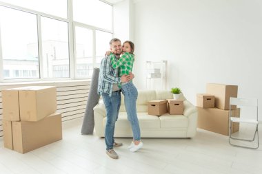 Yeni evlerine taşınırken sevinç kucaklayan genç çift Loving. Genç ailenin hareketli ve ev ısınması kavramı.