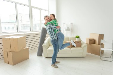 Denim pantolon genç çift hareket sırasında yeni dairede sevincini kucaklayan. Yeni konut için housewarming ve kredi kavramı.
