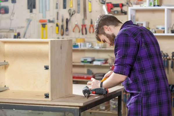 Jonge bebaarde man werkzaam bij de meubelfabriek — Stockfoto