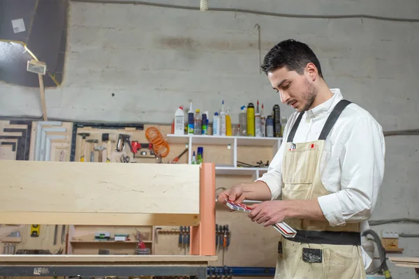 Jonge bebaarde man werken bij de meubelfabriek, kleur matching voor meubels — Stockfoto