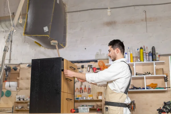 Meubelfabriek, kleine bedrijven en People concept-Young Man werkzaam bij de meubelproductie — Stockfoto