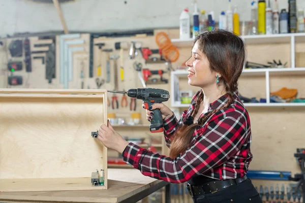 Meubelfabriek, kleine bedrijven en vrouwelijke werknemers concept-vrouw met een boor op de fabriek. — Stockfoto