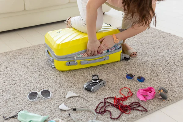 Concepto vacaciones, viajes y vacaciones - Mujer tratando de cerrar la maleta con un montón de cosas — Foto de Stock