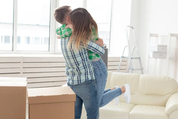 Невідома молода пара обіймає і танцює у вітальні своєї нової квартири. Концепція доступної іпотеки та нового житла для молодої сім'ї . — стокове фото