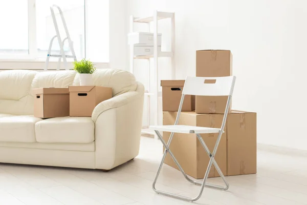 Klappsessel-Sofa und Kästen stehen im neuen Wohnzimmer, wenn die Bewohner in eine neue Wohnung ziehen. das Konzept der Neubauten und des komfortablen Wohnens für junge Menschen. — Stockfoto