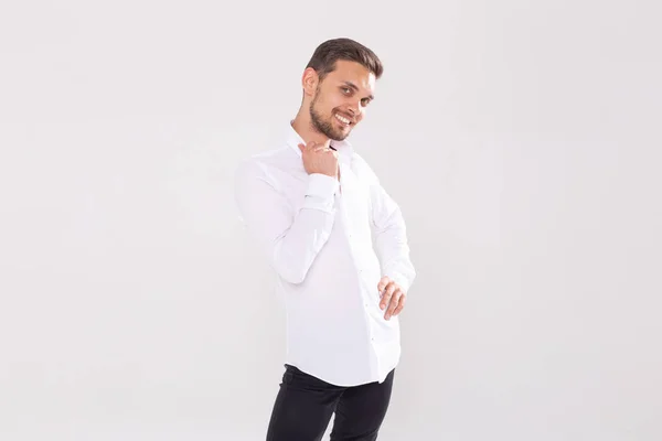 Retrato de belo jovem feliz em camisa casual em pé contra fundo branco com copyspace — Fotografia de Stock