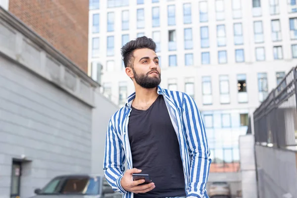 Hombre joven árabe moderno con teléfono móvil en la calle. Retrato exterior . — Foto de Stock