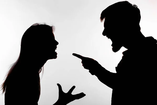 Aggression and abuse concept - man and woman expressing domestic violence in studio silhouette isolated on white background. — Stock Photo, Image