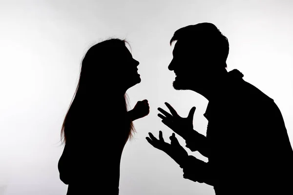 Концепция агрессии и насилия - мужчина и женщина выражают домашнее насилие в студийном силуэте, изолированном на белом фоне . — стоковое фото