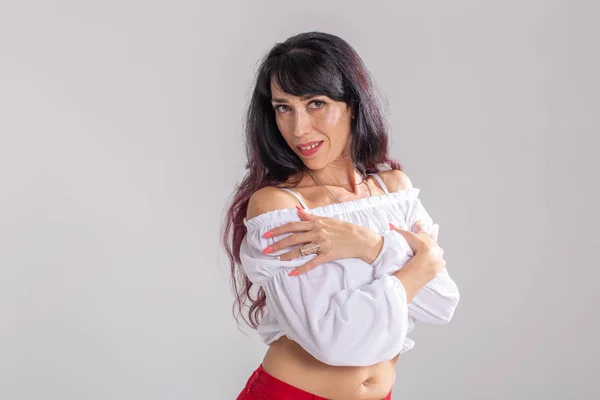 Latina dance, strip dance, contemporary and bachata lady concept - Γυναίκα που χορεύει αυτοσχεδιασμό και κινεί τα μακριά μαλλιά της σε λευκό φόντο — Φωτογραφία Αρχείου