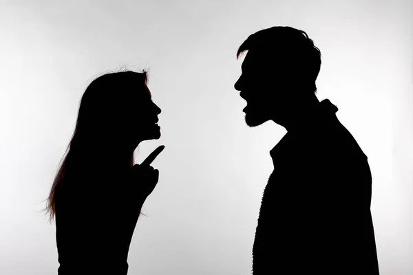 Concetto di aggressione e abuso - uomo e donna che esprimono violenza domestica nella silhouette dello studio isolati su sfondo bianco . — Foto Stock