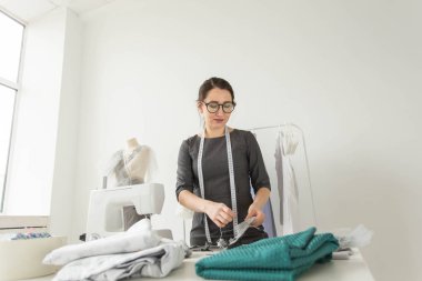 Terzi, moda tasarımcısı, terzi ve insanlar kavramı - iş yerinde bir kadın terzi portresi
