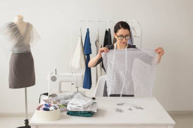 Terzi, moda tasarımcısı ve terzi kavramı - genç kadın moda tasarımcısı onu galeride çalışıyor