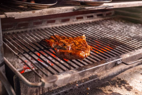 Food, craft and delicious concept - cooking steak on a grill — Stock Photo, Image