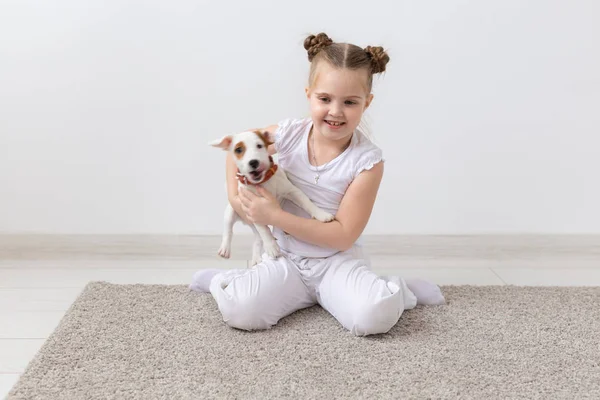 Mascotas y concepto animal - Niña jugando con el cachorro Jack Russell Terrier — Foto de Stock