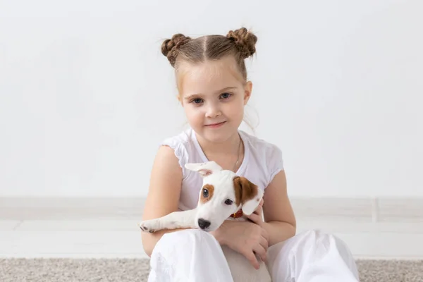 Pets and animal concept - Child girl playing with puppy Jack Russell Terrier — Stock Photo, Image