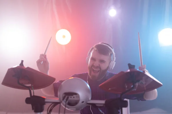 Hobby, música y concepto de personas - retrato de un hombre con auriculares blancos tocando la batería, divirtiéndose — Foto de Stock