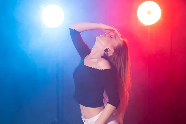 Dans, zarafet ve zerafet kavramı - genç kadın dans bachata bayan tarzı karanlıkta, ışıklar ve duman — Stok fotoğraf