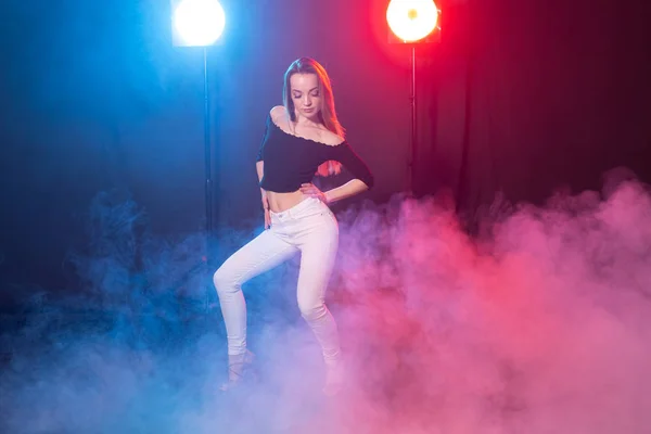 Concepto de danza, gracia y elegancia: mujer joven bailando el estilo de dama bachata en la oscuridad, luces y humo —  Fotos de Stock