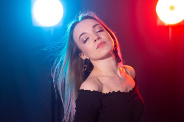 Gece kulübü, gece hayatı ve insan konsepti-karanlıkta poz veren genç kadın