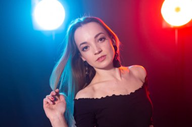 Gece kulübü, gece hayatı ve insan konsepti-karanlıkta poz veren genç kadın