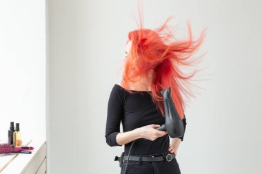 Stilist, moda, kuaför, insan kavramı - kadın onu renkli saç kurutma