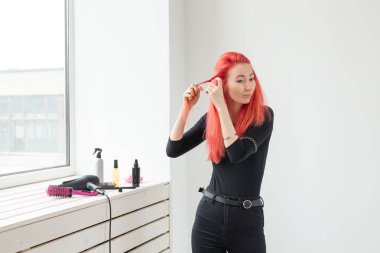 Uzun saçlı güzel kızıl saçlı kız, o bir güzellik salonunda, bir örgü örgü olduğunu. Profesyonel saç bakımı ve saç oluşturma.