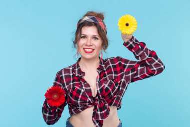 Yaz, pin-up ve eğlenceli kavram - mavi arka plan üzerinde gerberas ile güzel kadın