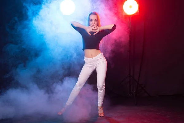Танец, грация и концепция - молодая женщина танцует в стиле леди в темноте, свете и дыму — стоковое фото