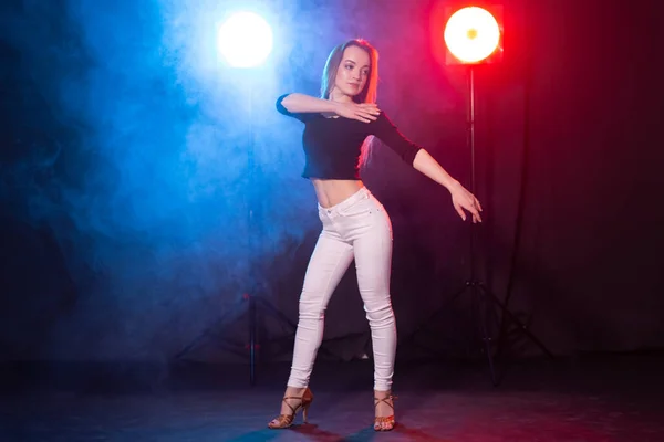 Éjszakai élet és klub koncepció-fiatal nő táncol a sötétben a fények — Stock Fotó