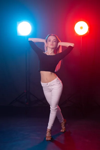 Concepto de danza, gracia y elegancia: mujer joven bailando el estilo de dama bachata en la oscuridad, luces y humo — Foto de Stock