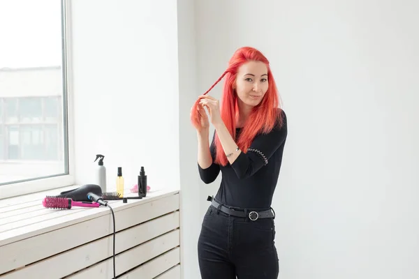 Schöne rothaarige Mädchen mit langen Haaren, sie ist webt einen Zopf, in einem Schönheitssalon. professionelle Haarpflege und Frisurengestaltung. — Stockfoto