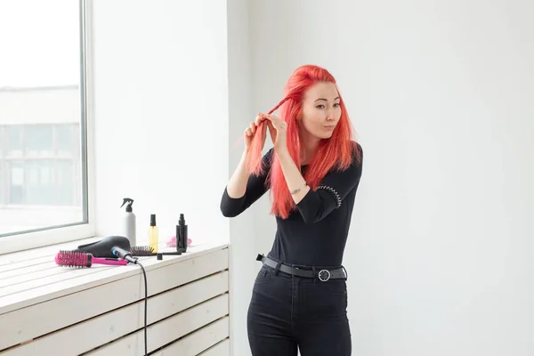 Schöne rothaarige Mädchen mit langen Haaren, sie ist webt einen Zopf, in einem Schönheitssalon. professionelle Haarpflege und Frisurengestaltung. — Stockfoto